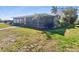 Rear exterior view of home featuring a screened lanai and tropical foliage at 513 Flamingo Dr, Apollo Beach, FL 33572