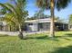 Charming fenced-in home with tropical palm trees in the front yard at 513 Flamingo Dr, Apollo Beach, FL 33572