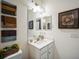 Neutral bathroom featuring single sink vanity, mirror, decor and artwork at 17936 Polo Trl, Bradenton, FL 34211
