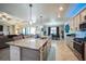 Open-concept kitchen featuring a large center island, pendant lighting, and stainless steel appliances at 17936 Polo Trl, Bradenton, FL 34211