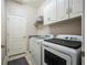 Functional laundry room with modern washer and dryer units, storage cabinets and tiled floor at 17936 Polo Trl, Bradenton, FL 34211