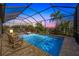 Screened pool with spa, tropical landscaping, and lounge seating at 17936 Polo Trl, Bradenton, FL 34211