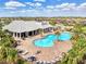 Aerial view of a community pool with brick patio, lounge chairs, and palm trees on a sunny day at 17936 Polo Trl, Bradenton, FL 34211