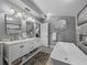 Elegant bathroom with double vanity, large tub, and stylish fixtures, and grey paint at 650 Poinsettia Rd, Belleair, FL 33756
