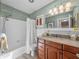 Bathroom with a single sink vanity and a shower with a white shower curtain at 650 Poinsettia Rd, Belleair, FL 33756