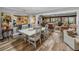 Open-concept dining area with white wood table, chairs and bar area with granite counters at 650 Poinsettia Rd, Belleair, FL 33756