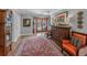 Elegant foyer featuring a large rug, hardwood floors, and a decorative wooden dresser at 650 Poinsettia Rd, Belleair, FL 33756