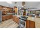Well-equipped kitchen featuring granite countertops, wood cabinetry, stainless steel appliances, and hardwood floors at 650 Poinsettia Rd, Belleair, FL 33756