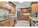 Well-lit kitchen with stainless steel appliances, granite counters and wood cabinetry at 650 Poinsettia Rd, Belleair, FL 33756