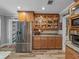 Modern kitchen boasts stainless steel refrigerator, wood cabinetry, granite countertops, and hardwood floors at 650 Poinsettia Rd, Belleair, FL 33756