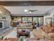 Spacious living room with stone fireplace, comfortable seating, and screened outdoor patio access at 650 Poinsettia Rd, Belleair, FL 33756