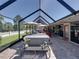 Extensive screened patio with a hot tub, outdoor seating, and a view of the meticulously kept yard at 650 Poinsettia Rd, Belleair, FL 33756