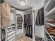 Well-organized walk-in closet with custom shelving, hanging racks, and shoe storage with tiled floor at 650 Poinsettia Rd, Belleair, FL 33756
