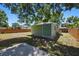View of the grassy, fenced backyard with the exterior green of the house at 1206 E Hamilton Ave, Tampa, FL 33604