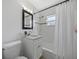 Well-lit bathroom featuring a vanity, framed mirror, updated fixtures, shower-tub combo, and a toilet at 1206 E Hamilton Ave, Tampa, FL 33604