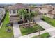 Large two-story home featuring a well-manicured lawn, tropical landscaping, and a three-car garage at 2709 Coco Palm Cir, Wesley Chapel, FL 33543