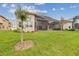 A sprawling lawn with rear elevation view showing tall windows and outdoor patio area at 2709 Coco Palm Cir, Wesley Chapel, FL 33543