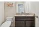 Well-lit powder room with granite counters, modern toilet, and decorative wall art at 2709 Coco Palm Cir, Wesley Chapel, FL 33543