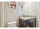 The bathroom has a granite vanity top with wooden cabinets, a comfort-height toilet, and artwork at 2709 Coco Palm Cir, Wesley Chapel, FL 33543