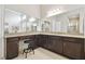 Well lit bathroom vanity area with granite counters, dark cabinets and a stool at 2709 Coco Palm Cir, Wesley Chapel, FL 33543
