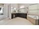 Well lit bathroom with granite counters, dark cabinets, a soaking tub and separate shower at 2709 Coco Palm Cir, Wesley Chapel, FL 33543