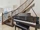 Elegant foyer featuring a grand piano, wrought iron staircase, and luxurious marble floors at 2709 Coco Palm Cir, Wesley Chapel, FL 33543