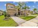 Stunning two-story home with a paver driveway, lush lawn, and meticulously maintained landscaping at 2709 Coco Palm Cir, Wesley Chapel, FL 33543