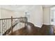 Hallway with dark wood floors, decorative railing, and curved design at 2709 Coco Palm Cir, Wesley Chapel, FL 33543