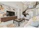 A spacious living room with a grand staircase, stylish furniture, and elegant lighting at 2709 Coco Palm Cir, Wesley Chapel, FL 33543