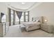 Bright main bedroom featuring neutral decor, tray ceiling, large windows, and stylish furnishings at 2709 Coco Palm Cir, Wesley Chapel, FL 33543