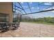 Covered patio area with an outdoor table and chair set with view of trees in the background at 2709 Coco Palm Cir, Wesley Chapel, FL 33543