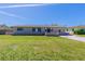 Charming single-story home with a well-manicured lawn and concrete driveway under a clear blue sky at 6730 32Nd N Ave, St Petersburg, FL 33710