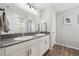 This bathroom offers double sinks with modern fixtures and wood look floors at 7617 Wallflower Trl, Wesley Chapel, FL 33545
