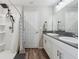 This bathroom offers double sinks with modern fixtures, wood look floors and a walk in shower at 7617 Wallflower Trl, Wesley Chapel, FL 33545