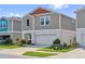 Exterior view of a home showcasing its well-kept lawn and two car garage at 7617 Wallflower Trl, Wesley Chapel, FL 33545