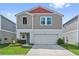 Charming two-story home featuring a well-maintained lawn and an attached two-car garage at 7617 Wallflower Trl, Wesley Chapel, FL 33545