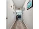 Inviting hallway with wood flooring and tasteful decor leading into the living spaces at 7617 Wallflower Trl, Wesley Chapel, FL 33545