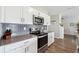 Beautiful kitchen features white cabinets, stainless steel appliances, and modern backsplash at 7617 Wallflower Trl, Wesley Chapel, FL 33545