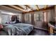 Relaxing bedroom featuring exposed beam ceilings, natural light, and a comfortable king-size bed at 18218 Railroad Rd, Spring Hill, FL 34610