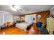 Cozy bedroom with warm wood paneling and a comfortable bed, complemented by hardwood floors at 18218 Railroad Rd, Spring Hill, FL 34610