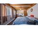 Bright bedroom with exposed beam ceilings, hardwood floors, and plenty of natural light at 18218 Railroad Rd, Spring Hill, FL 34610