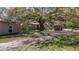 Exterior view of ranch-style home surrounded by lush greenery and mature trees at 18218 Railroad Rd, Spring Hill, FL 34610