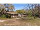Exterior front view of home with trees, front porch, and yard at 18218 Railroad Rd, Spring Hill, FL 34610