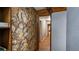 Interior hallway featuring a unique stone accent wall and wood-look flooring throughout at 18218 Railroad Rd, Spring Hill, FL 34610