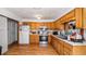 Open kitchen with wood cabinets, updated appliances, and view into living room at 18218 Railroad Rd, Spring Hill, FL 34610