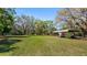 Large grassy yard with mature trees and covered RV storage at 18218 Railroad Rd, Spring Hill, FL 34610