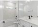 Modern bathroom with white tile, tub and shower combination, and a white sink at 3363 Sikeston Ave, North Port, FL 34286