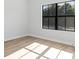 Bright bedroom featuring wood-look flooring, modern trim, and a large window overlooking a lush yard at 3363 Sikeston Ave, North Port, FL 34286