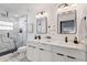 Bright bathroom featuring a double vanity, marble countertops, modern fixtures, and a marble tile shower at 4907 21St W Ave, Bradenton, FL 34209
