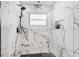 Modern tile shower featuring marble tiling, glass doors, modern shower fixtures and a window at 4907 21St W Ave, Bradenton, FL 34209